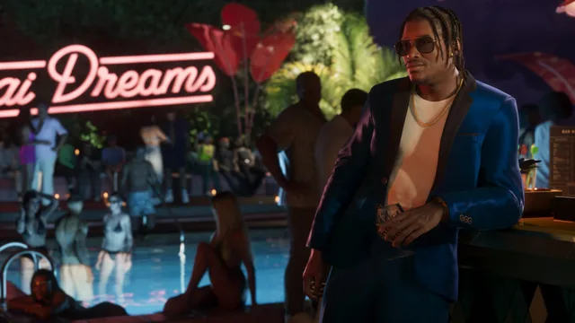 Dre’Quan in a suit at a nighttime pool party