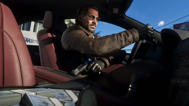 Raul driving with a handgun, an open bag full of cash beside him