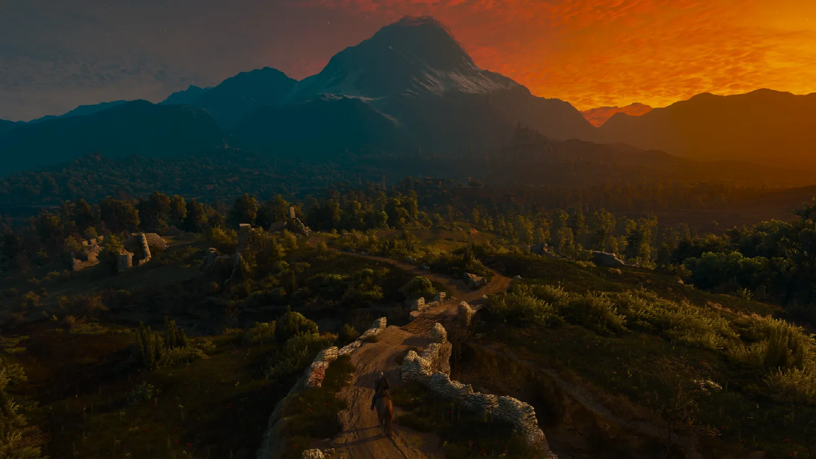 Weite Landschaft in The Witcher 3 bei Sonnenuntergang mit Bergen und Wäldern